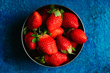 Ripe and juicy strawberries on the dark rustic background. Selective focus. Shallow depth of field.