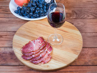Red wine and cured pork slices on cutting board