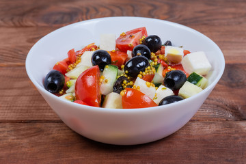 Vegetable salad with soft cheese in bowl close-up