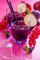 Fruit juice rich of anthocyanins, oligominerals for health in glass on colored background.