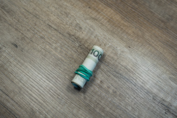 Money rolled up with an elastic band on table. Roll of polish currency. Polish zloty banknotes. Polish money. PLN