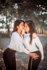  Two Twin teenage girls young woman laughting and having fun near the garden at sunset time