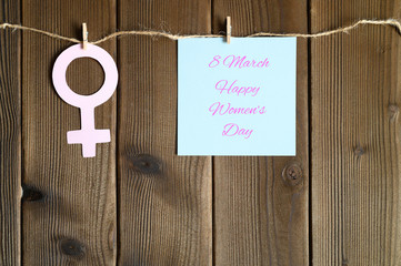female symbol cut out of paper and sticky note with the inscription 