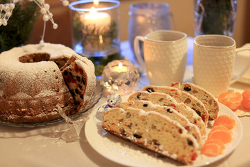 Christmas cupcake with dried fruits from prunes, raisins, dried cherries and nuts on the background of a tea set, Christmas tree branches and a lit candle