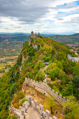 Fototapeta na wymiar Italy, the Guaita tower in San Marino is illuminated by the bright summer sun, blue sky and clouds.