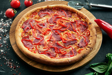 Delicious close up view on Spicy sliced pizza with ham, onion and chili. Traditional italian cuisine.
