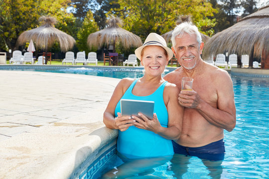 Seniors with tablet in the swimming pool