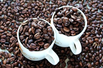 cup of coffee with beans on wooden background