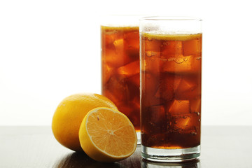 Glasses with cuba libre cocktail or cola with ice or cold tea with lemon