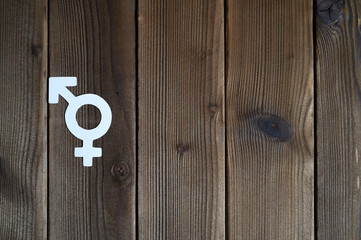 symbol for gender equality cut out of paper on a wooden background. space for text