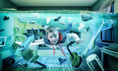 child plays happy with an airplane in his flooded room.
