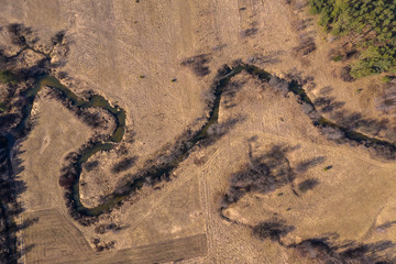 Aerial drone view on autumn landscape. Aerial view on small river in golden autumn forest