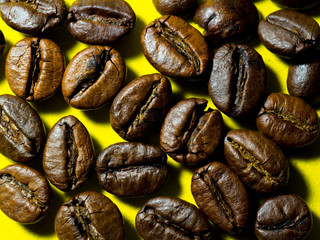 contrasting image of coffee beans on a bright yellow background top view