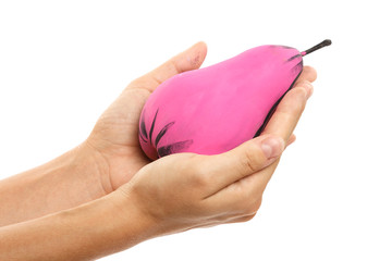 Female hand and creatively decorated pink pear
