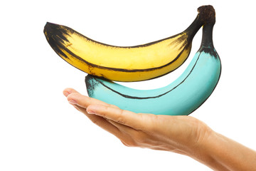 Female hand and creatively decorated colorful bananas