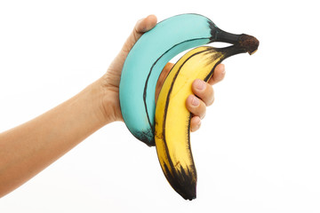 Female hand and creatively decorated colorful bananas