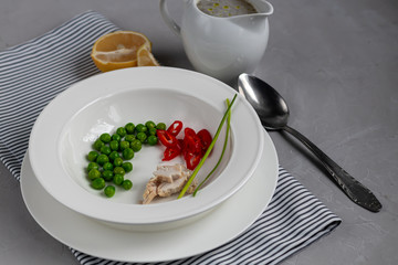 Diet soup made from fresh vegetables and chicken breast. Fo bo. Green peas chives and chili peppers.