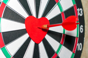 Red heart on a dart board, dart hitting the target. Valentine's day concept. Soft focus