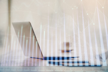 Double exposure of graph and financial info and work space with computer background. Concept of...