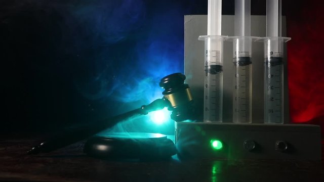 Lethal injection concept. Prisoner handcuffed to death by lethal injection. Creative artwork decoration with scale model on dark with lights.