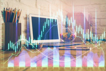 Double exposure of graph and financial info and work space with computer background. Concept of international online trading.