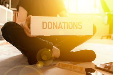 a man carry the donation box to give it to children as charity, human help and assistance