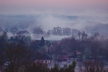 Cold autumn morning in the village. Morning fog over trees