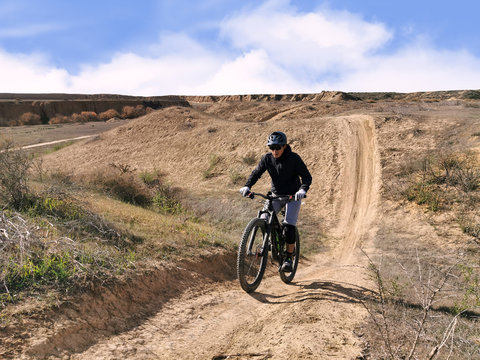 Mountain biker rides on a sandy sungle track