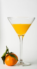 A glass of orange juice accompanied by an orange on a white background.
