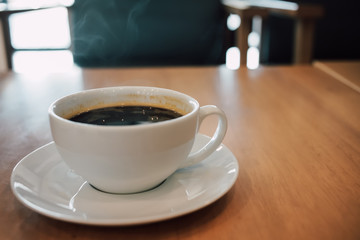 Aroma cup of coffee on a wooden table in the morning