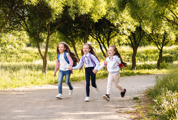 Obraz premium School kids running to school outdoors, full length