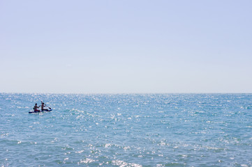 Two men swimming on a long board in the sea or ocean in a sunny day. Surfing and vacation concept.