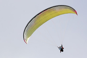 Tandem Paraglider flying wing in a blue sky	