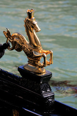 Golden sea horse statue with crown decorating a gondola on the Canal Grande in Venice, Italy © schusterbauer.com