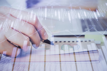Multi exposure closeup hands with stock market forex graph.