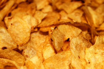 Fresh and crispy buttery potato chips close up on horizontal photo