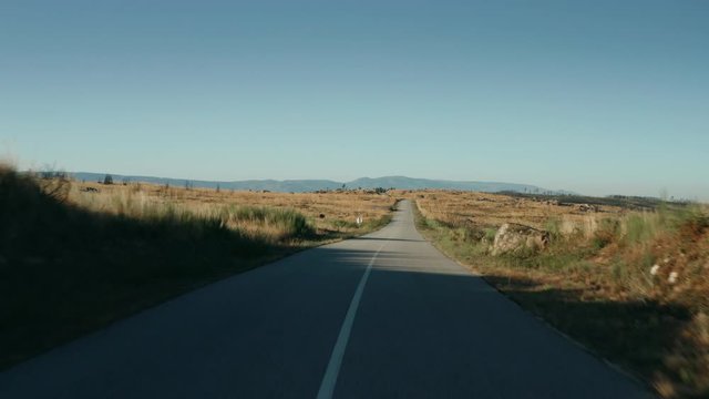 Take off on a road in the middle of the mountain. Drone shot from gorund to the sky