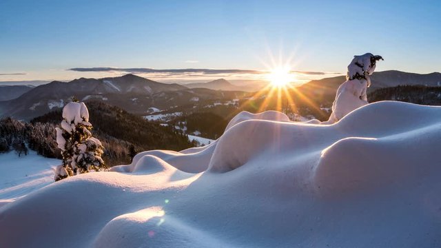 Sunset over snowy nature in cold winter mountains landscape time lapse