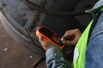 worker in factory checking quality of metals