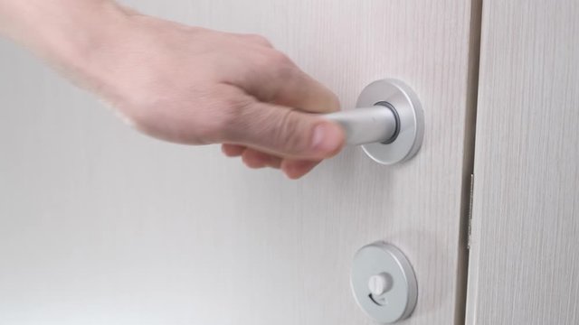 Person close wooden door bathroom with light. Slow motion.