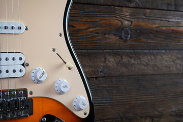 Close-up on electric guitar on vintage old wooden background