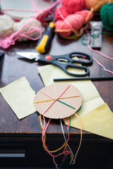 Making a braided friendship bracelet using a cardboard and yarn.