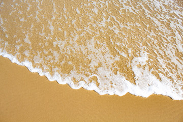 Espuma da onda do mar e areia em dia de sol