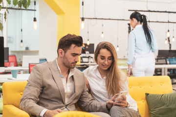 Man in suit and beauty woman sitting and working on phone