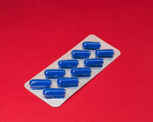 pack of blue pills on a red background