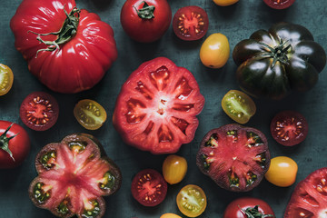 Fresh juicy tomatoes on green background, top view.