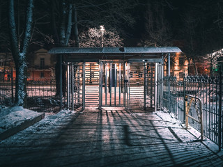 Turnstile, restricted entry. Closed gate exit to the street of the night winter city
