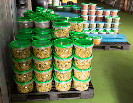 Rows of plastic containers with pickled olives