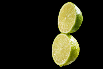 Green fresh organic kiwi halves on black background