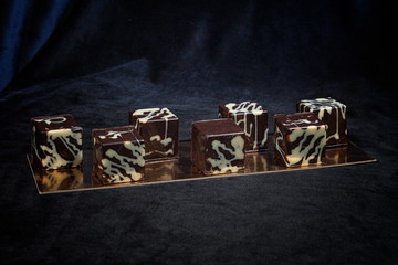 hand-made chocolates, each candy is different and unique. Dark chocolate on velvet and gold